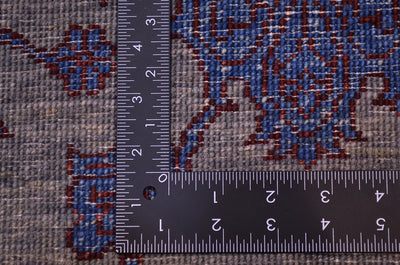 Reverse of handmade rug showing fine knotting and back of individual knots in greys, blue and chestnut brown-red.