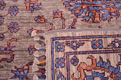 Reverse of rug and close up of handknotting of Sultani rug with grey/light brown field colour with blue and orange/ terracotta floral detailing, outlined with rich chestnut brown contrast.