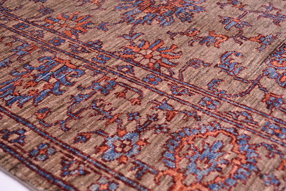 Detail of floral border of handmade rug with traditional Persian floral design with dual hued detailing and neutral grey brown background.