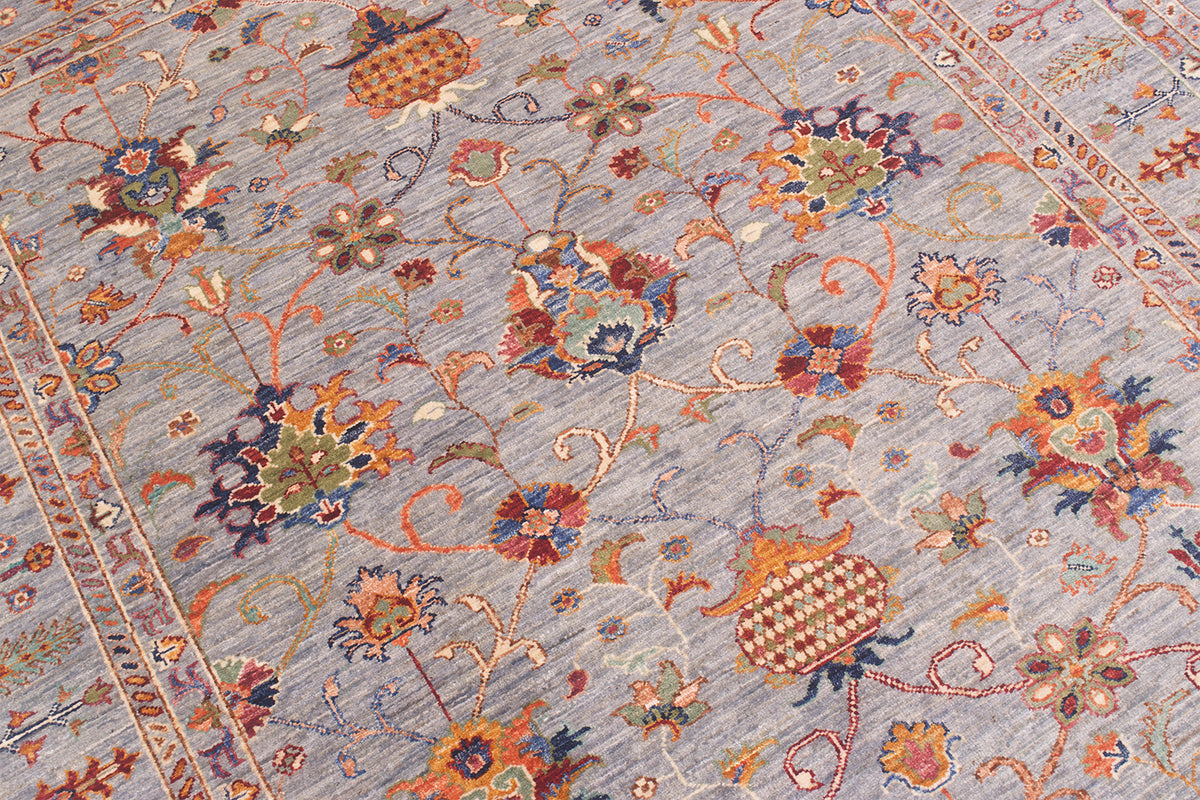 Close up detailed view of main field of Sultani carpet with decorative palmetss and pomegranates and traditional Persian motifs. Soft bluish grey field colour.