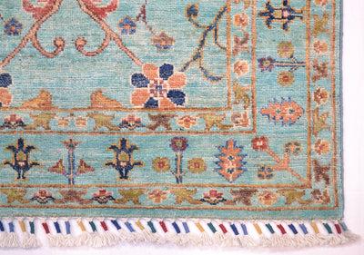 Corner detail of multicoloured handknotted rug with cotton warp fringes bound with colourful  woollen yarn. Handspun pure wool pile.