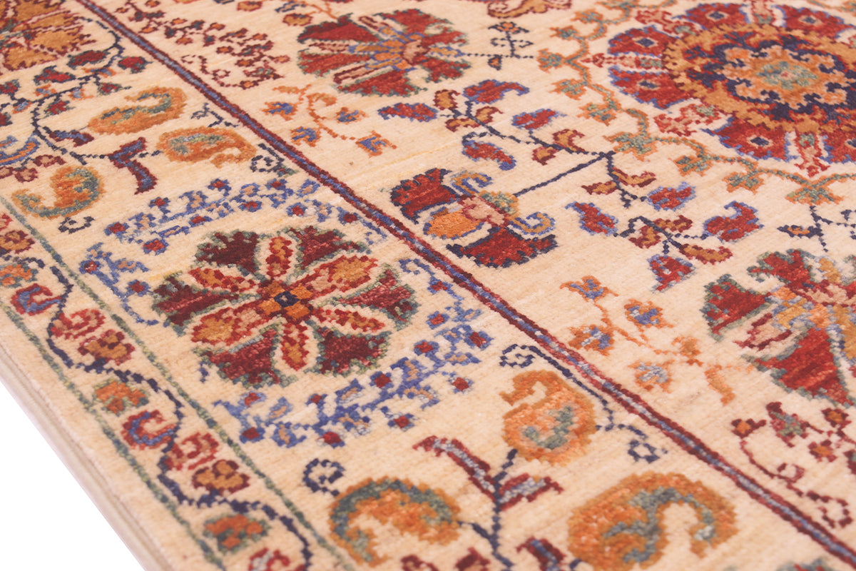 Rug close-up of corner medallion and geometric border in red, blue, orange on cream