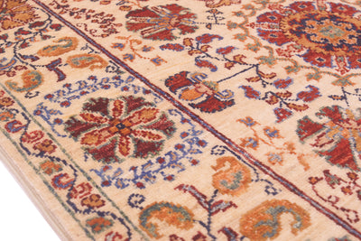 Rug close-up of corner medallion and geometric border in red, blue, orange on cream