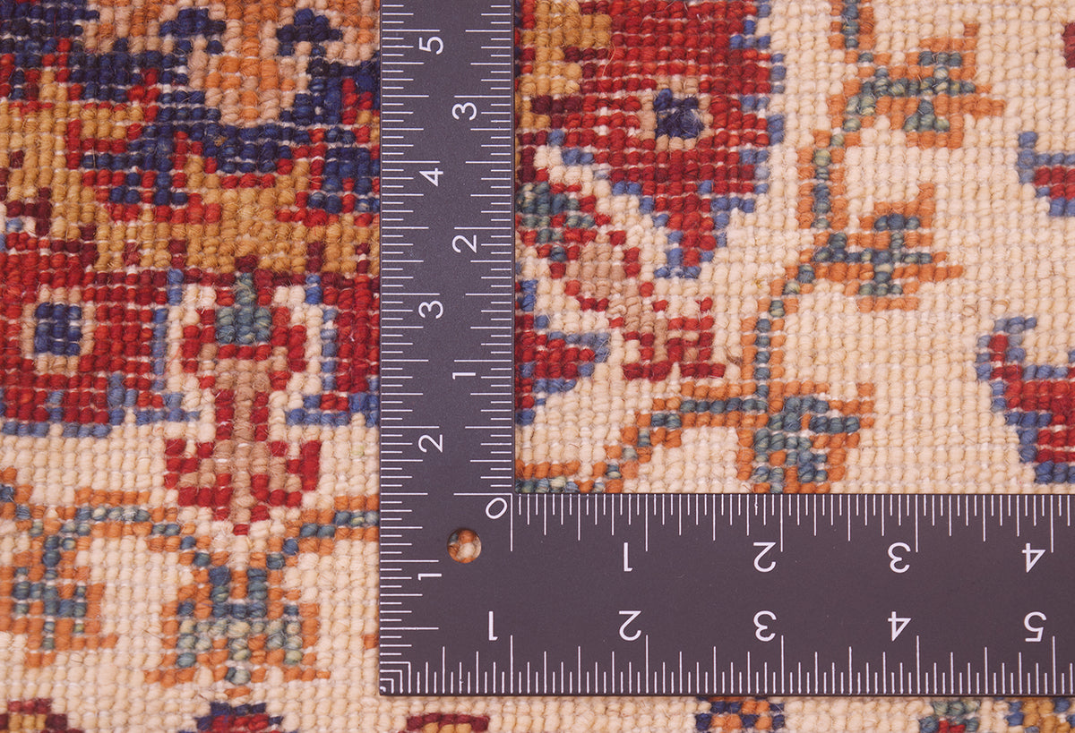 Rug weave close-up with multicolor pattern beside inch ruler for measurement