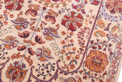 Rug close-up of floral pattern panels with red, blue and orange accents on cream