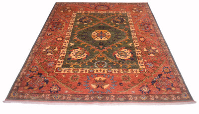 An Afghan Suzani design handmade carpet with a complex floral and medallion pattern, featuring a rust red outer border, a dark green central field, and beige and blue accents.