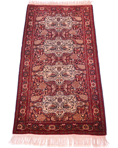 Old Belouch-Tavusi rug angled view with ornate red and cream motifs, light pink fringe.