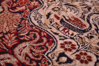 Old Belouch-Tavusi rug close-up of red and cream floral motifs with fine detailing.