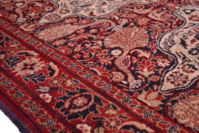Old Belouch-Tavusi rug close-up showing red border details and cream vine ornaments.