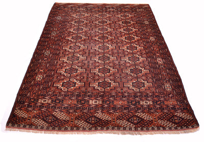 A traditional Turkoman Tekke antique wool rug with a geometric pattern in shades of brown, orange, beige, and black, shown flat against a white background.