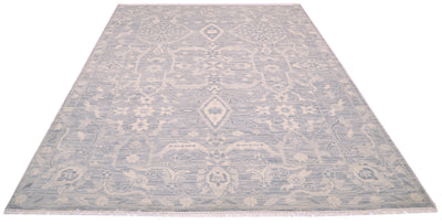 A rectangular area rug with a traditional floral geometric pattern in light grey and cream, shown from a top-down perspective on a white background.