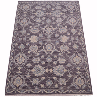 A rectangular tonal  rug with an ornate floral and vine pattern in muted pewter, beige, and light blue, shown flat against a white background.