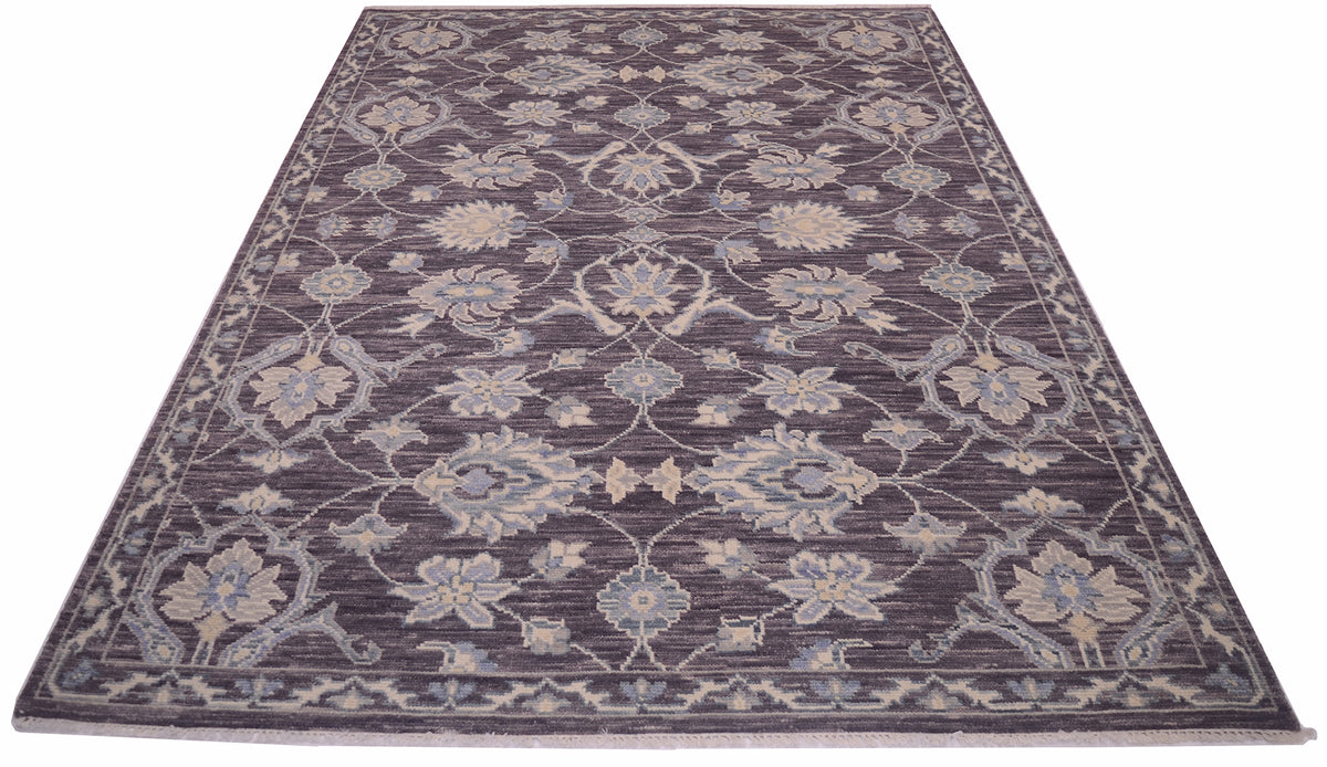 A rectangular Tonal rug with an intricate traditional floral pattern in shades of pewter, beige, and light blue, shown from a top-down perspective on a white background.