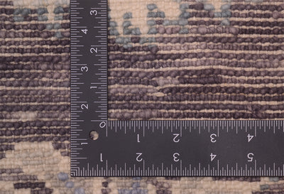 Close-up of the back of a Tonal  rug with a floral pattern in beige,and muted blue and pewter, shown with a black ruler for scale