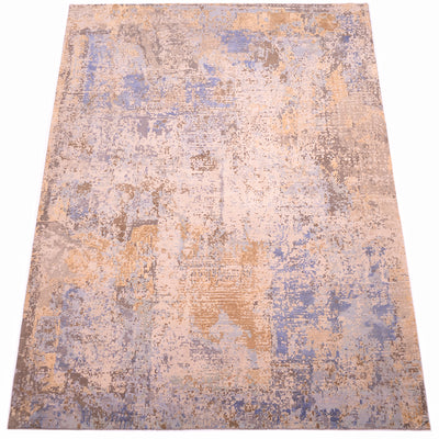 Overall view of indain handmade abstract carpet with wool pile and reasied silk area of golden creams, light and mid blues. Areas of dark bronze and stone beige in background  gorund colour of wool pile.