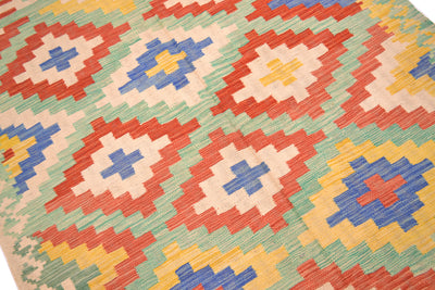 Handwoven kilim rug close-up of geometric cross shapes in red, blue, yellow, green