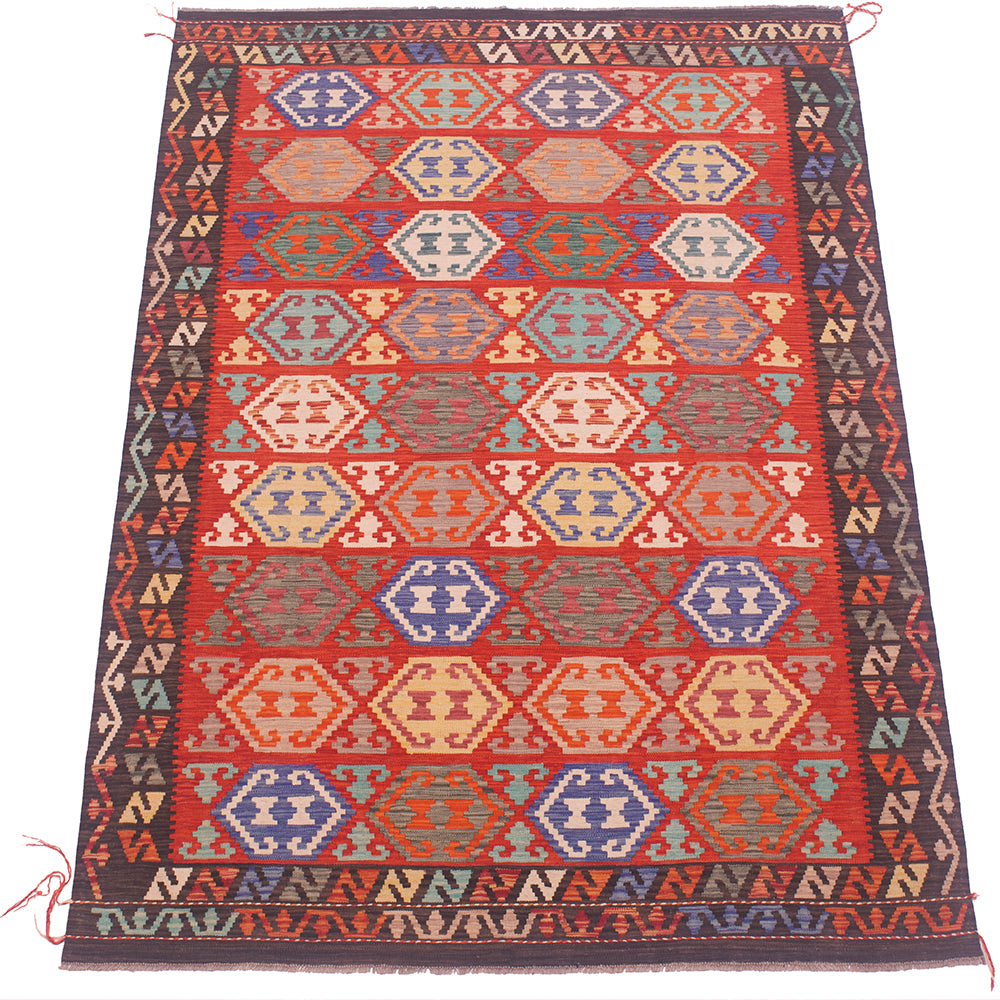 A flat-laid kilim rug with a vibrant red field, decorated with repeating geometric diamond and hexagon motifs in blue, beige, and orange, framed by a dark patterned border.