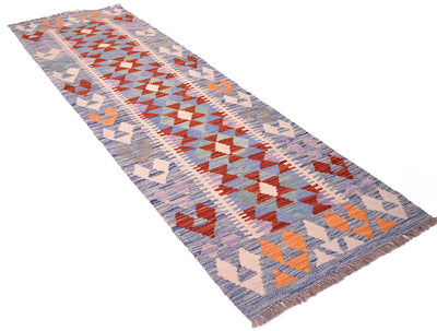 A 2m long rectangular handwoven short Kilim Runner rug with a geometric tribal pattern in muted blue, orange, red, cream, and lavender tones, finished with fringed ends, shown on a plain white background.