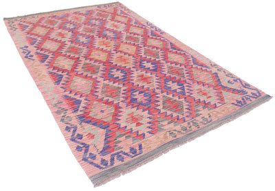 A 6x4 Afghan kilim area rug with a geometric diamond pattern in pink, red, blue, and beige, featuring a fringed edge on a white background.