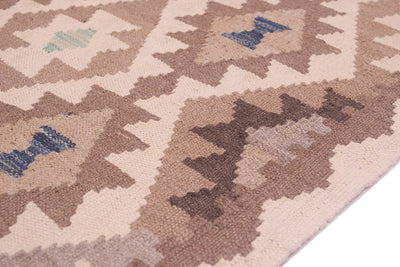 Close-up of a woven Afghan Natural Dye Kilim Runner with a geometric tribal pattern in beige, brown, and muted blue, shown on a white surface.