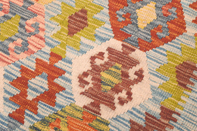 Handwoven kilim rug close-up with central diamond medallion in rust, yellow, and blue
