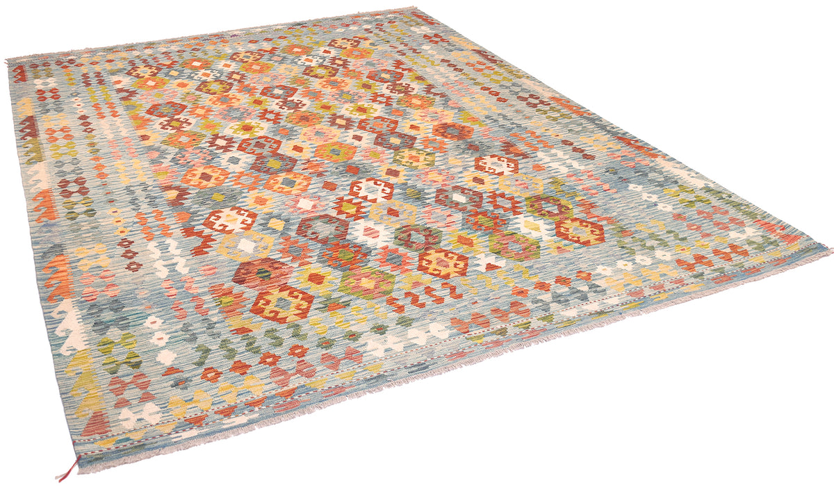 Large handwoven kilim rug shown from a corner angle with multicolor geometric motifs