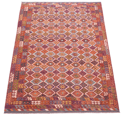 Handwoven kilim rug with stepped diamond motifs in orange, red, purple, and white.