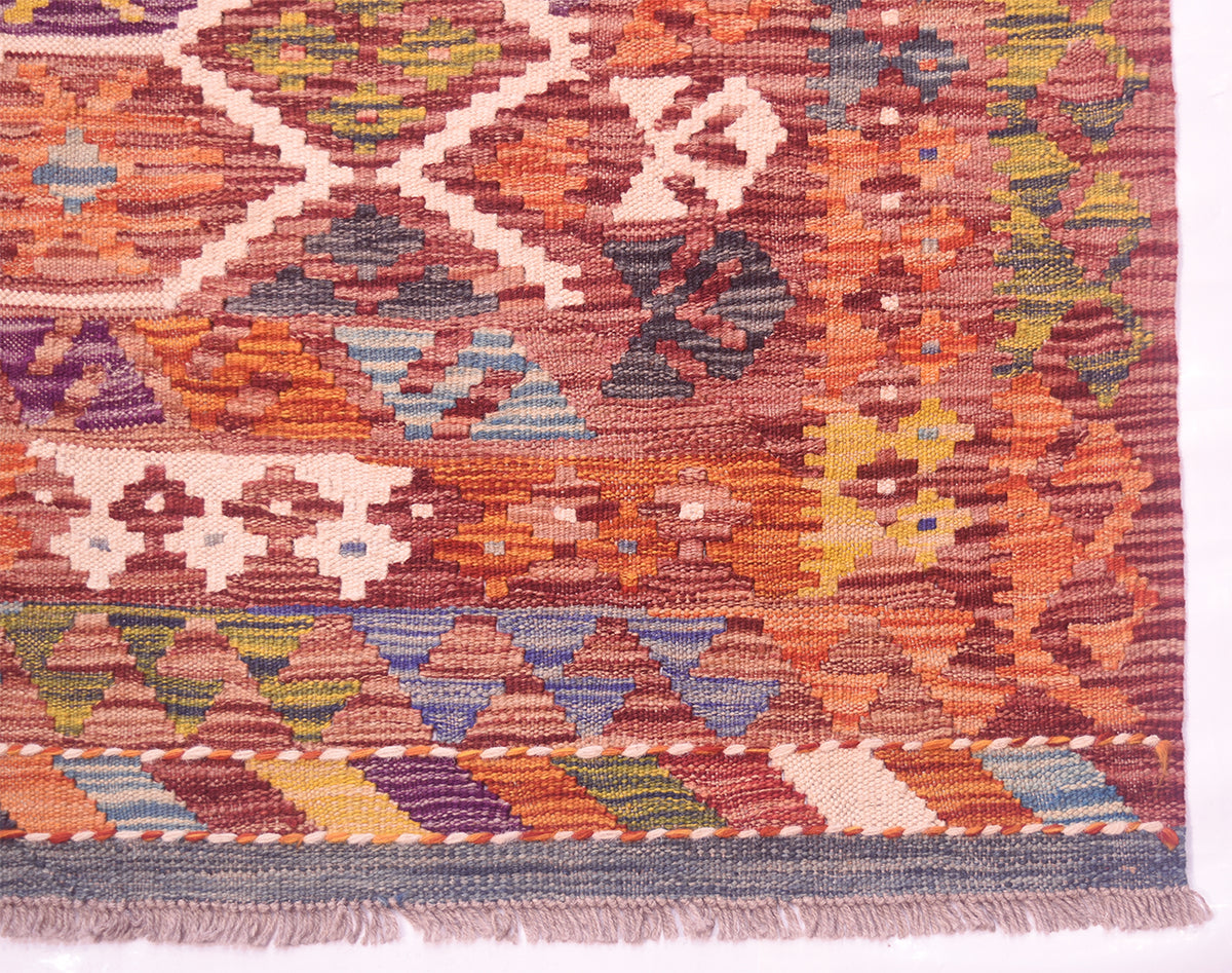Handwoven kilim rug edge with flat woven border and multicolor geometric pattern.