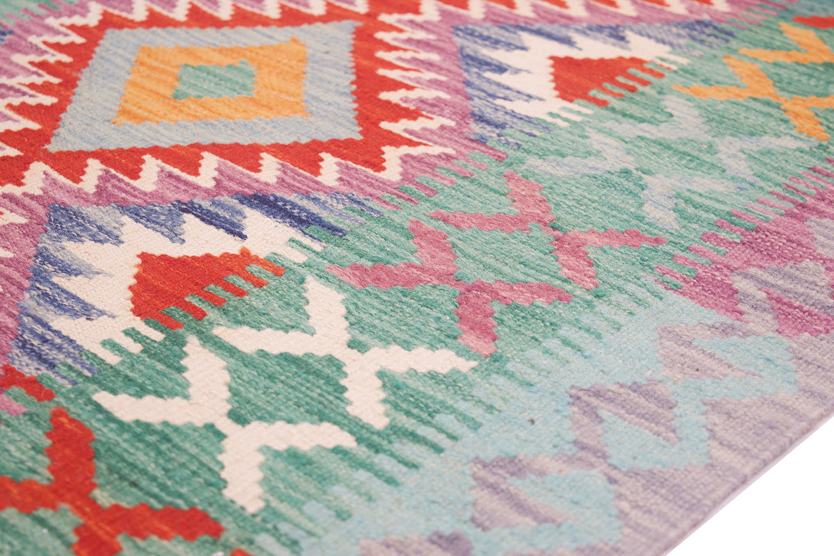 Colorful kilim rug close-up with pastel blue, green, pink, and red zigzag blocks