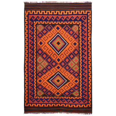 Colorful vintage Kilim rug with diamond medallion in orange, navy, and rust; fringed edges.