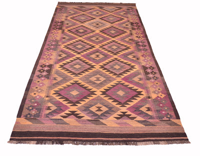 A rectangular handwoven vintage Afghan Kilim wide runner rug with a geometric diamond pattern in shades of pink, purple, brown, beige, and black, featuring fringe on the top and bottom edges.