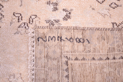 Reverse of  cream blue and beige vintage carpet showing back of handknotting and cotton warp foundation and fringes. Shaven softened coloured zero pile detail. 