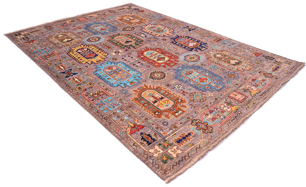 A rectangular Afghan-style Waziri rug with an intricate multicolour pattern, featuring a grey base with red, orange, yellow, and blue motifs, shown on a plain white background.