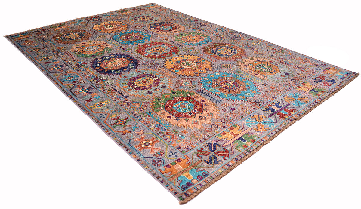 A rectangular Afghan colourful Waziri  rug with an intricate geometric and medallion pattern in muted blue, beige, orange, and brown tones, shown from an elevated angle on a white background.