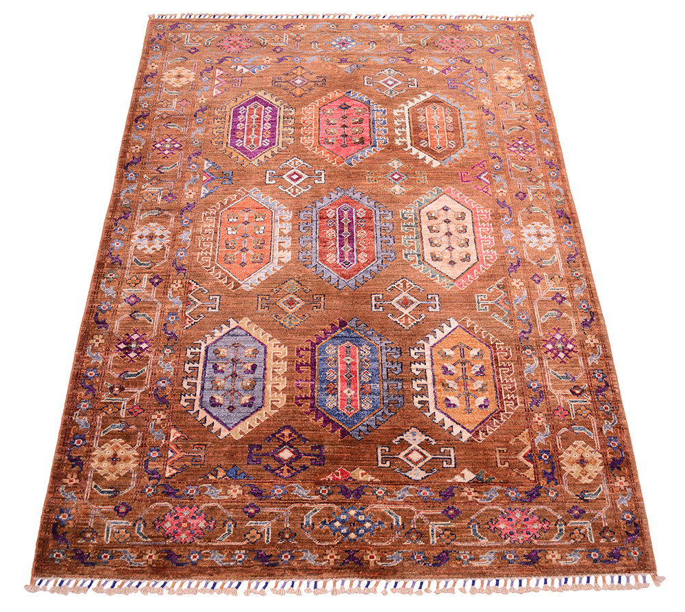 A 6x4 rectangular Afghan cinnamon Waziri rug area rug with a warm brown base and a complex geometric medallion pattern in red, blue, purple, beige, and orange, finished with fringed edges.