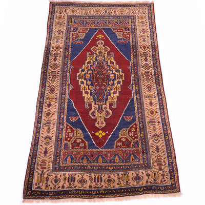 A traditional old Turkish-style Yahyali wool rug with a central red medallion, blue corners, and apricot borders with intricate geometric patterns, shown flat against a white background.