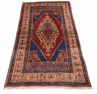 A traditional Yahyali-style Turkish area rug with a central red diamond medallion, navy blue borders, and beige accents, shown flat against a white background.