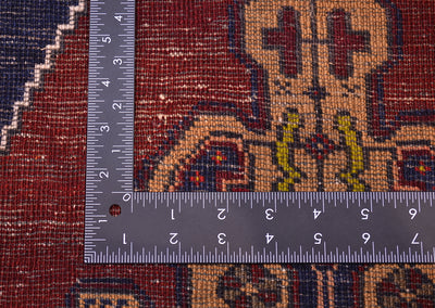 Close-up of the hand-knotted weave of a patterned Old Turkish Yahyali rug with a metal L-square ruler placed over it to show scale of the knotting.