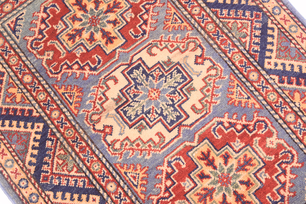 Handmade Afghan Yakash Kazak rug close-up of medallion pattern in red, blue, and cream