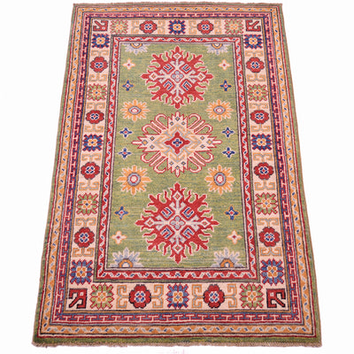 Handmade green wool rug, angled view, red and blue geometric medallions with border