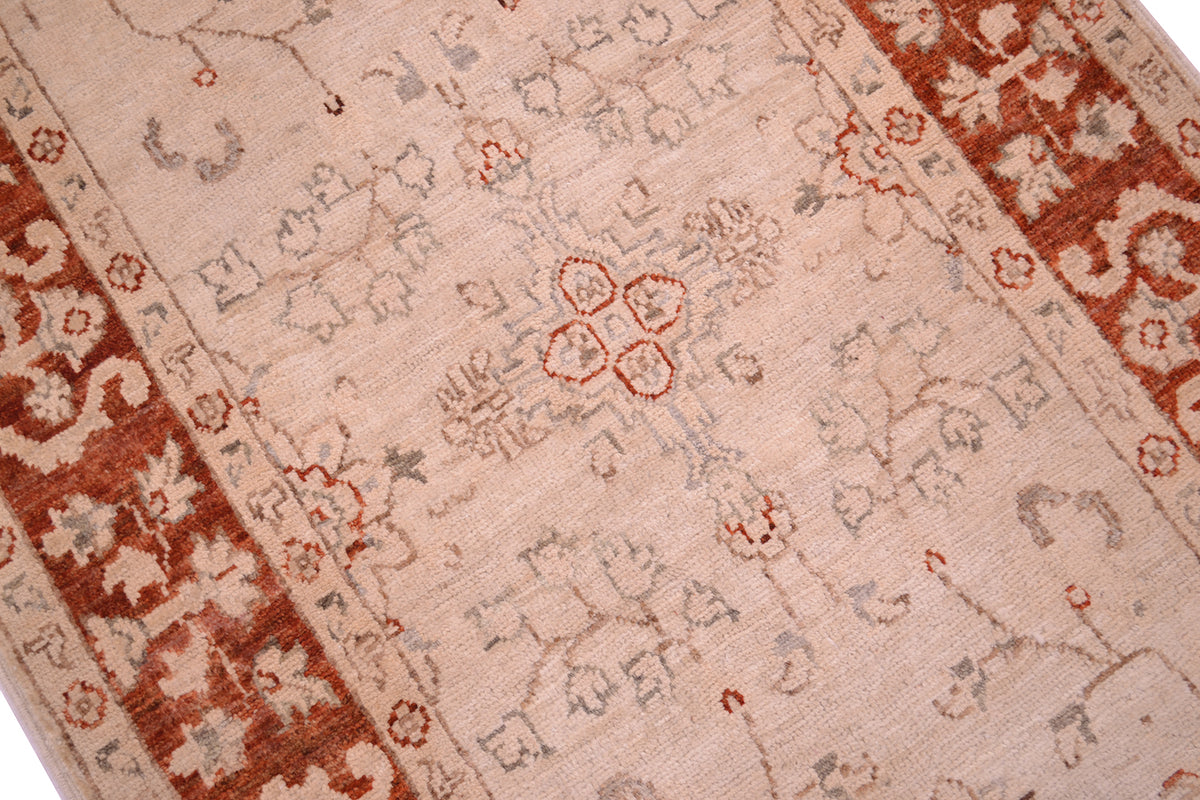 Detail and close view of afghan handmade made runner strip with cream beige main field with delicate tracery floral motifs outlined in greys with rust coloured border.