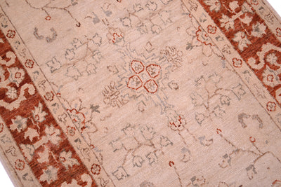 Detail and close view of afghan handmade made runner strip with cream beige main field with delicate tracery floral motifs outlined in greys with rust coloured border.