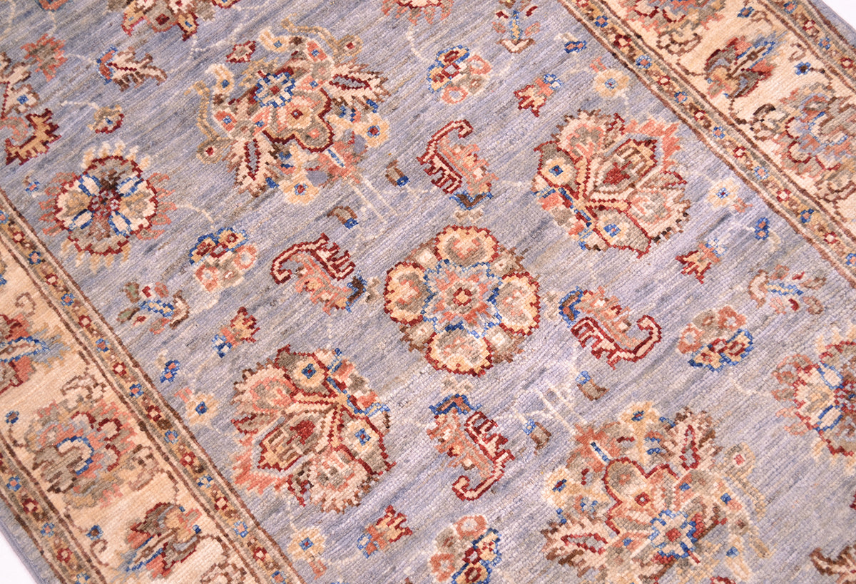 Detailed view of main grey blue field of afghan runner with floral design.