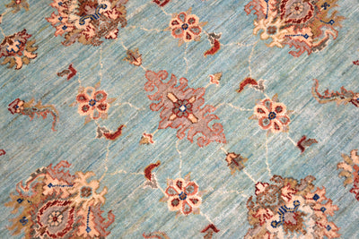 Close detail of handknotted pile of light blue aqua tones with soft coloured palmette and decorative flowers