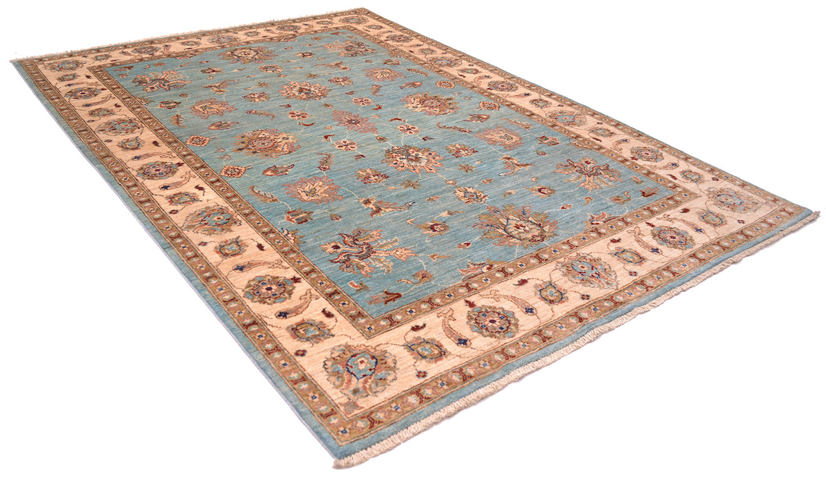 Angled view of a handwoven Ziegler design carpet with golden cream border and light blue field with florals