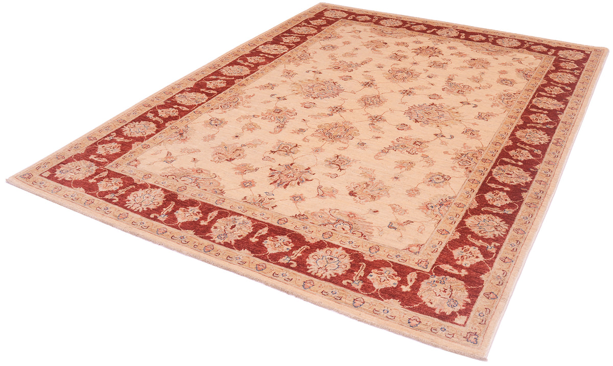 Angled view of hankntted carept with elegnat all over traditional floral design with linked sectioned flowers and flowing leaves.