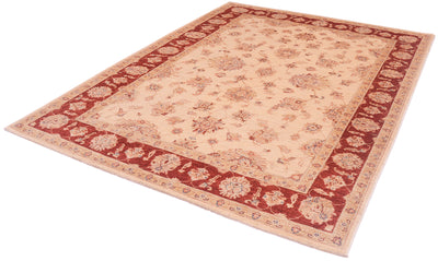 Angled view of hankntted carept with elegnat all over traditional floral design with linked sectioned flowers and flowing leaves.