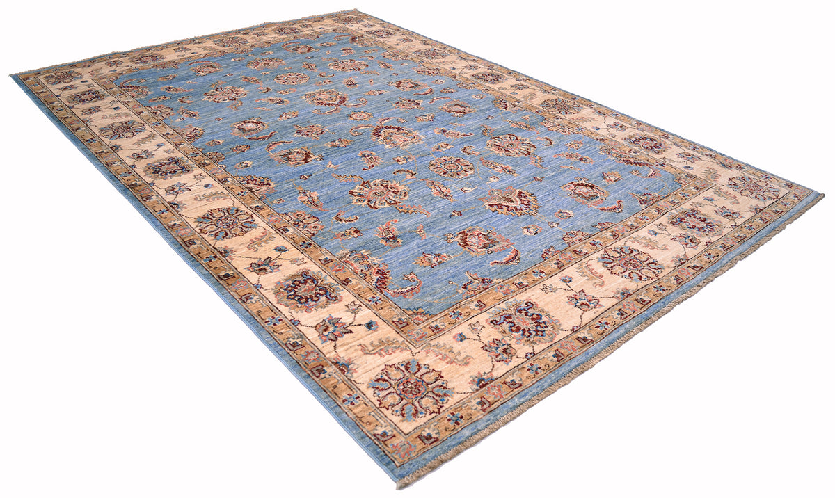 Angled view of handmade carpet with hunspun wool in light blue and cream