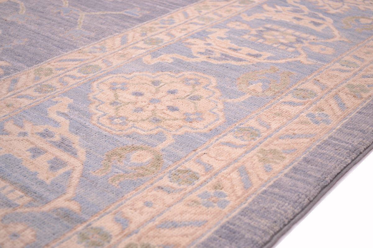 Pastel blue rug corner with medallion motif and border edging