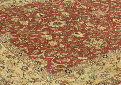 Detailed view of main field of amber rust toned field colour of oversize handknotted carpet with curvilinear  all-over floral motifs  within field and border. Roundels and rosettes and tendrils in main field.